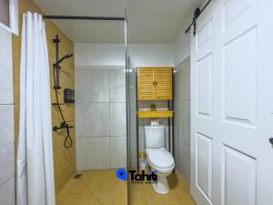 a bathroom with a toilet and a shower at Moorea Temae Surf Tiny House in Teavaro +27 photos