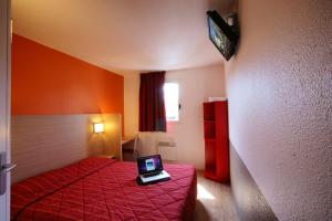 Pokój z łóżkiem z laptopem na stole w obiekcie Première Classe Rosny Sous Bois w mieście Rosny-sous-Bois