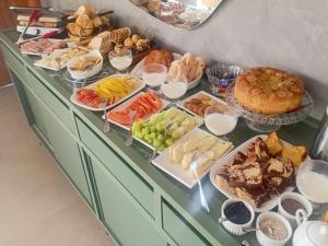 a buffet filled with different types of bread and pastries at Pousada Varandas do Lago in Capitólio +14 photos