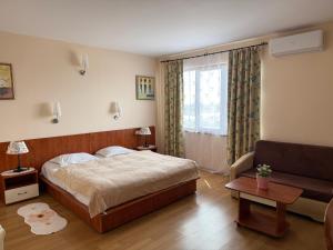 a bedroom with a large bed and a couch at Златна люспа in Bŭlgarevo