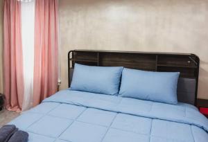 a bed with blue pillows sitting in a bedroom at The Slate and Stone House in Buffalo
