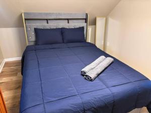 a bed with blue sheets and two towels on it at The Slate and Stone House in Buffalo +2 photos