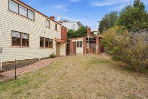 an empty yard in front of a house at Charming Sandy Bay Cottage in Sandy Bay