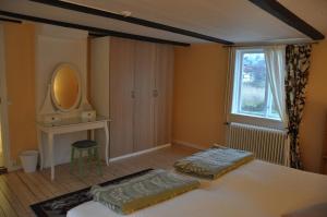 a bedroom with a bed and a mirror at The Gardener House - Grönsöö Palace Garden in Grönsöö +4 photos