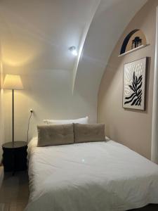 a bedroom with a white bed and a lamp at Tracce nel Borgo in Putignano