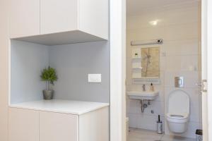 a white bathroom with a toilet and a sink at Don Vito in Belgrade +23 photos