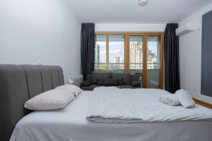 a bed with white sheets and pillows in a bedroom at Don Vito in Belgrade