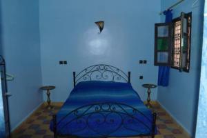 ein blaues Schlafzimmer mit einem Bett in einem blauen Zimmer in der Unterkunft Maison d'Hôte La Roche Noire in Fint