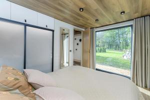 a bedroom with a large bed and a large window at CozyEst Meremõisa in Meremõisa