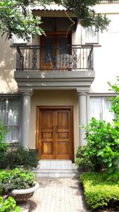 a house with a wooden door and a balcony at House Rossini in Pretoria
