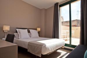 ein Schlafzimmer mit einem Bett und einem großen Fenster in der Unterkunft May Ramblas Hotel in Barcelona