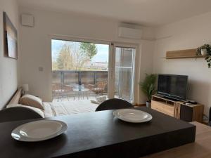 a living room with a table and a television at Pipanova Cosy Nest with Balcony & Free Parking in Ljubljana