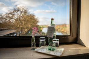 a window with vases and bottles on a window sill at Hotel Brückentor in Rinteln +55 photos
