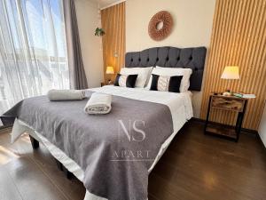 a bedroom with a large bed with a gray blanket at NORTHSUITE - Vista al Mar - 3 Dormitorios - Parking in Antofagasta