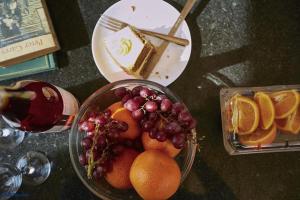 a bowl of fruit on a table with a plate of cake at Nature Lovers Camp in Sekenani