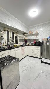 a large kitchen with white cabinets and a stove at Spring house in Qaryat Shākūsh +18 photos