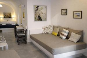 a living room with a couch and a dining room at Yposkafo Suites - Private Studio - Santorini in Fira +18 photos
