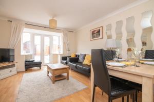 a living room with a table and a couch at Fantastic 4 bed house with 3 bathrooms in pleasant location in Great Barr