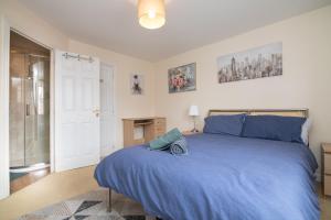 a bedroom with a blue bed and a glass door at Fantastic 4 bed house with 3 bathrooms in pleasant location in Great Barr
