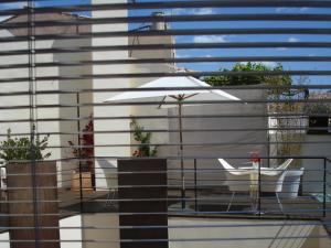 a balcony with two chairs and an umbrella at Cas Ferrer Nou Hotelet in Alcudia
