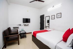 a bedroom with a bed and a chair and a tv at Starlight Hotel1Square in Pondicherry