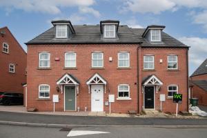 a red brick house with a white door at Fantastic 4 bed house with 3 bathrooms in pleasant location in Great Barr