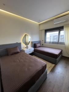 a bedroom with two beds and a window at Charming privado in Madinaty