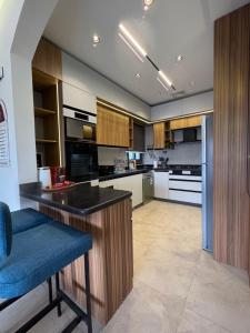 a large kitchen with a counter and a blue stool at Charming privado in Madinaty