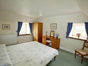 a bedroom with a bed and a desk and window at Coelard Farmhouse - Usj in Appin