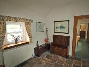 a living room with a window and a wooden chair at Coelard Farmhouse - Usj in Appin +2 photos