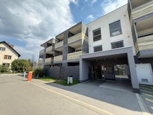 a large white building with a parking lot at Pipanova Cosy Nest with Balcony & Free Parking in Ljubljana