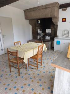 a kitchen with a table and chairs in a room at Maisonnette de campagne in Val Couesnon
