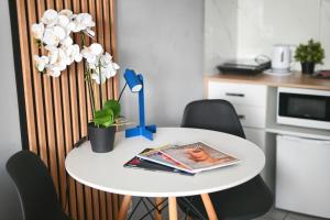 a white table with chairs and a magazine on it at Mini Apartamenty Poznań in Poznań