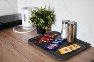 a black tray with a group of candy on a table at Mini Apartamenty Poznań in Poznań