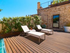 two lounge chairs on a deck next to a pool at Cas Ferrer Nou Hotelet in Alcudia
