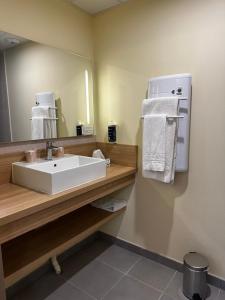 a bathroom with a sink and a mirror at Brit Hotel Montargis in Mormant-sur-Vernisson +16 photos