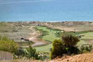 a golf course on a hill with the ocean in the background at Palmares Beach House Hotel - Adults Only in Lagos
