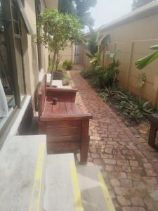 a patio with two benches on a brick sidewalk at Amru Guesthouse B&B in Brackenfell