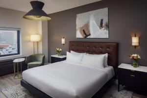 a hotel room with a large bed and a chair at Watt Hotel Tapestry Collection by Hilton in Rahway +29 photos