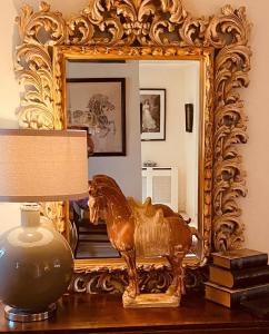 a statue of a horse on a table in front of a mirror at Little Campden House in Chipping Campden