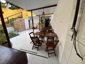 a patio with a wooden table and chairs at Pousada Sol E Mar in Morro de São Paulo