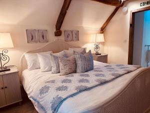 a bedroom with a large white bed with pillows at Little Campden House in Chipping Campden