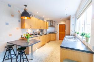 a kitchen with wooden cabinets and a table with flowers at SO-LUX in Belfast +131 photos