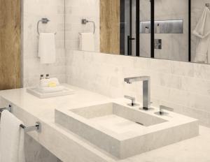 a white bathroom with a sink and a mirror at Jojos Palace Hotel - Gulu in Gulu