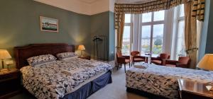 a bedroom with a bed and a desk and a window at The Portland Hotel in Folkestone
