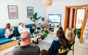 a group of people sitting in a living room watching a presentation at Green House in Baleal