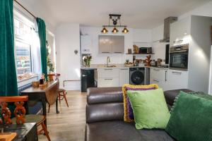 a living room with a couch and a kitchen at Shell Cottage in Bournemouth
