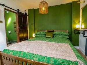 a bedroom with green walls and a large bed at Shell Cottage in Bournemouth