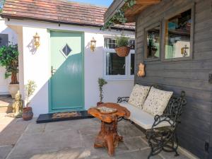 a porch with a bench and a table and a door at Shell Cottage in Bournemouth