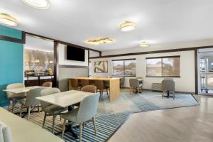 a dining room with tables and chairs and windows at Comfort Inn in Marion